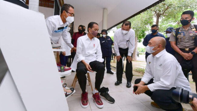 Presiden Joko Widodo saat mencoba sepatu produksi usaha mikro, kecil, dan menengah (UMKM) di kawasan UMKM Bazaar Mandalika, Kabupaten Lombok Tengah, Provinsi Nusa Tenggara Barat, pada Kamis, 13 Januari 2022. Foto: BPMI Setpres/Muchlis Jr