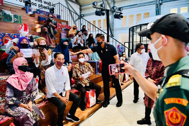 Presiden Joko Widodo meninjau proses penyaluran Bantuan Langsung Tunai (BLT) Minyak Goreng kepada 100 Keluarga Penerima Manfaat (KPM) yang digelar di Pos Bloc, Jakarta, pada Senin, 25 April 2022. Foto: BPMI Setpres