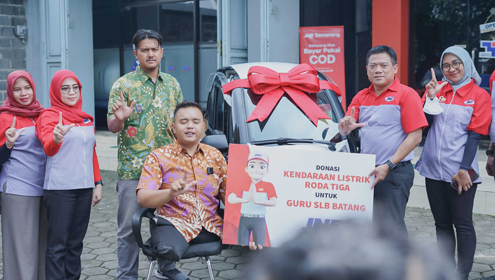SERAHKAN BANTUAN : Kepala Cabang Utama JNE Semarang, Wahyu Sangerti Alam menyerahkan bantuan kendaraan listrik kepada Mohamad Hikmat (Dok JNE)